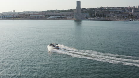 boat riding fast on river tejo near the descobrimetos monument