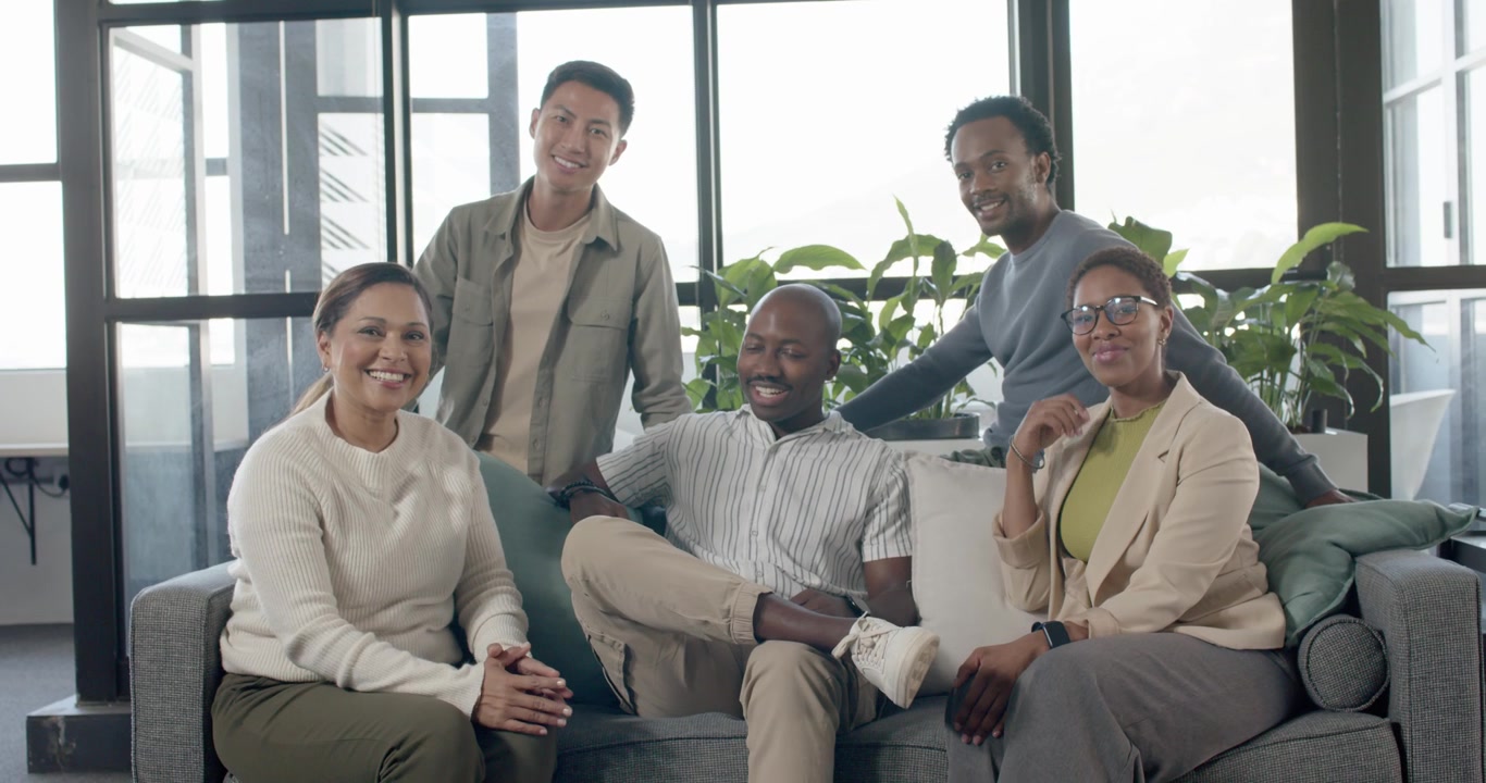 Diverse team, woman in sweater leading chat, listening, aligning for group shot on sofa in lounge