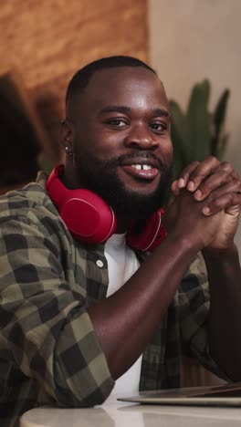 smiling man with headphones at laptop