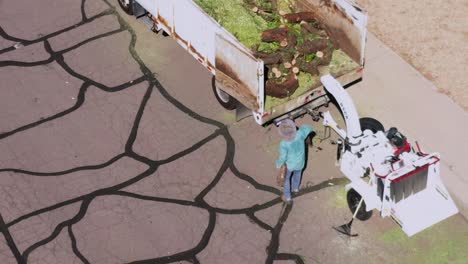 aerial drone man carries logs to the bed of a truck, scottsdale, arizona