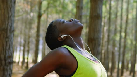 female jogger stretching in the forest 4k