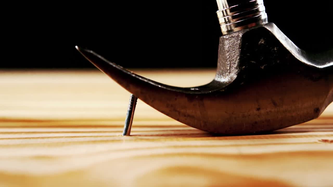 Hammer pulling nail from wood