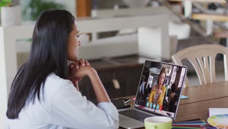 african american woman having a video call with female colleague on laptop at home