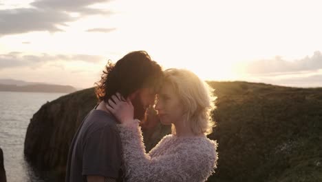 pareja abrazada contra el cielo al atardecer