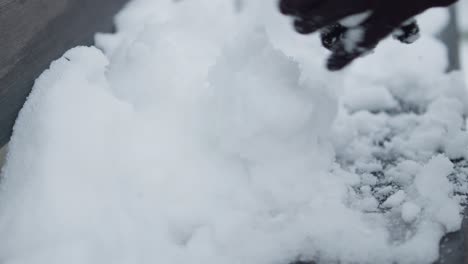 slowmotion closeup of preparing pile of snowballs with black gloves