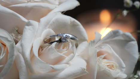 two white gold wedding rings among the white rose petals of the bride's bouquet