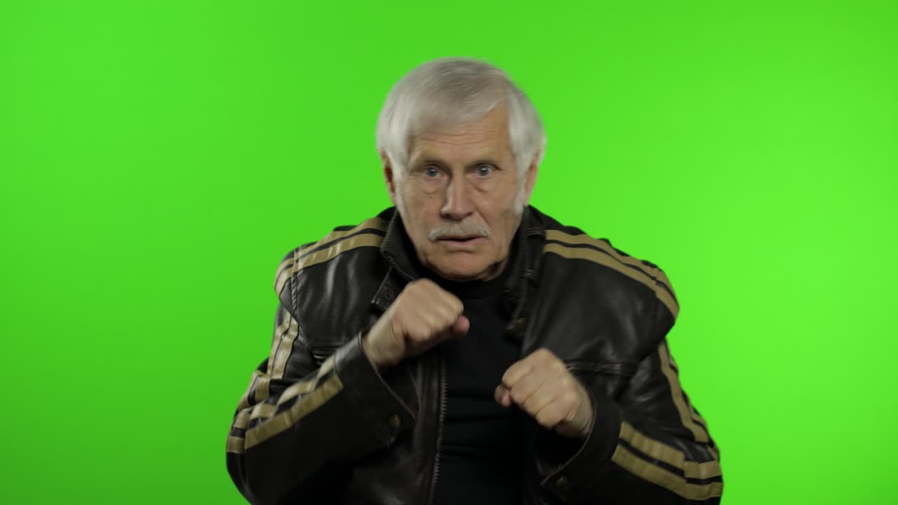 노인 백인 할아버지 로커 남자가 주먹 싸움을 보여줍니다.