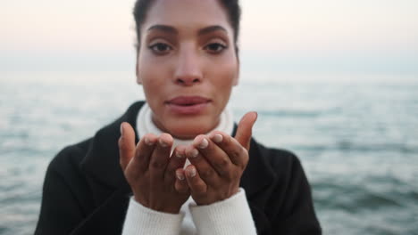 Smiling-African-American-girl-sending-air-kiss-to-camera.