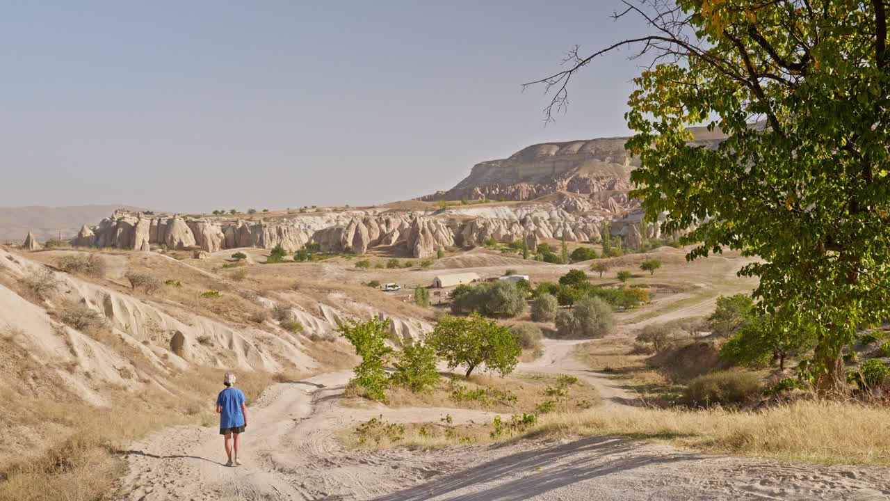 Caminhante na trilha do Vale das Rosas, paisagem geológica acidentada da Capadócia