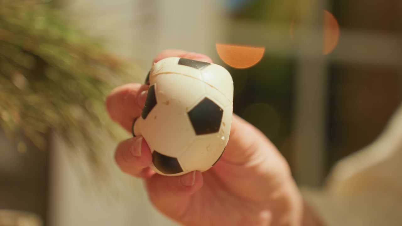 Close-up of Hand Squeezing a Small Soccer Ball Stress Toy