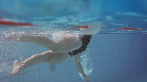 Unterwasseraufnahme-Einer-Frau,-Die-Im-Innenpool-Schwimmt