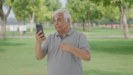 Angry-Indian-old-man-shouting-on-video-call-in-park