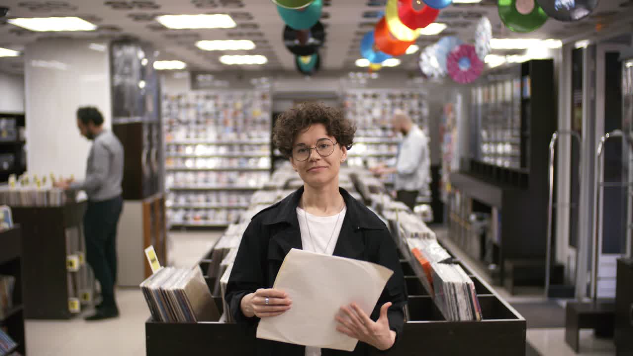 una coleccionista de música posando en una tienda de discos con vinilo raro