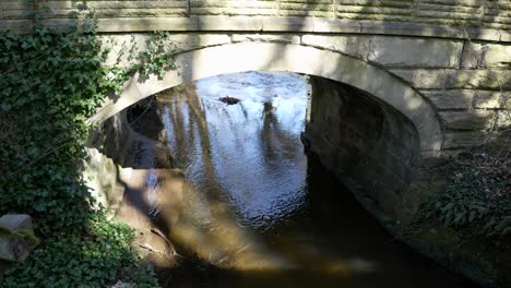 a river flowing gently under an old stone bridge