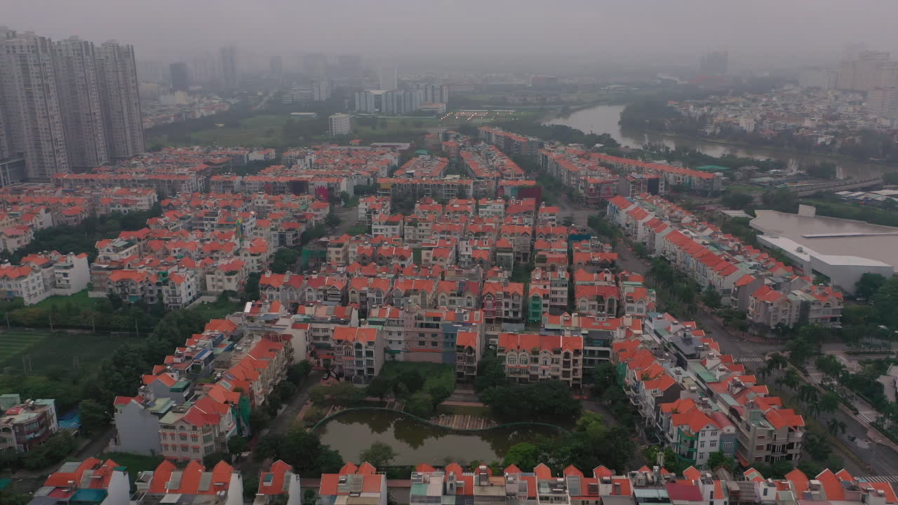 imágenes de drones brumosas y con smog a primera hora de la mañana sobre desarrollos urbanos de viviendas de gran altura y villas en el distrito siete de saigón, ciudad de ho chi minh, vietnam