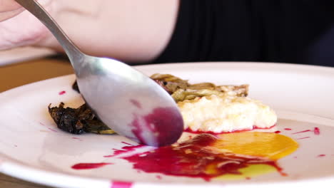 persona comiendo de un plato con salsa, cebolletas y puré, cierre lento