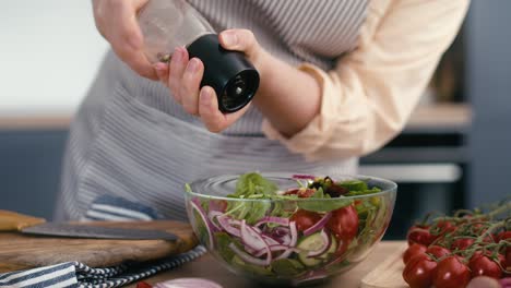 Kaukasische-Frau-Würzt-Den-Gesunden-Und-Frischen-Salat.