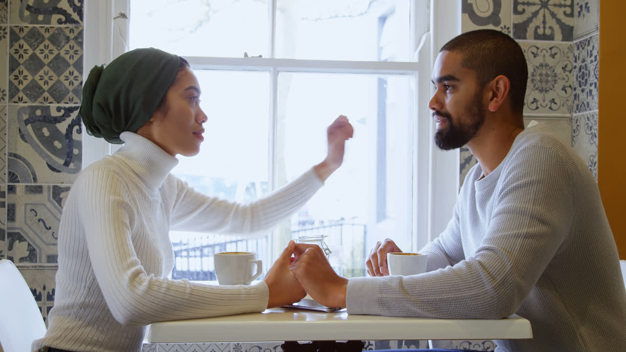 Couple interacting with each other in cafe 4k