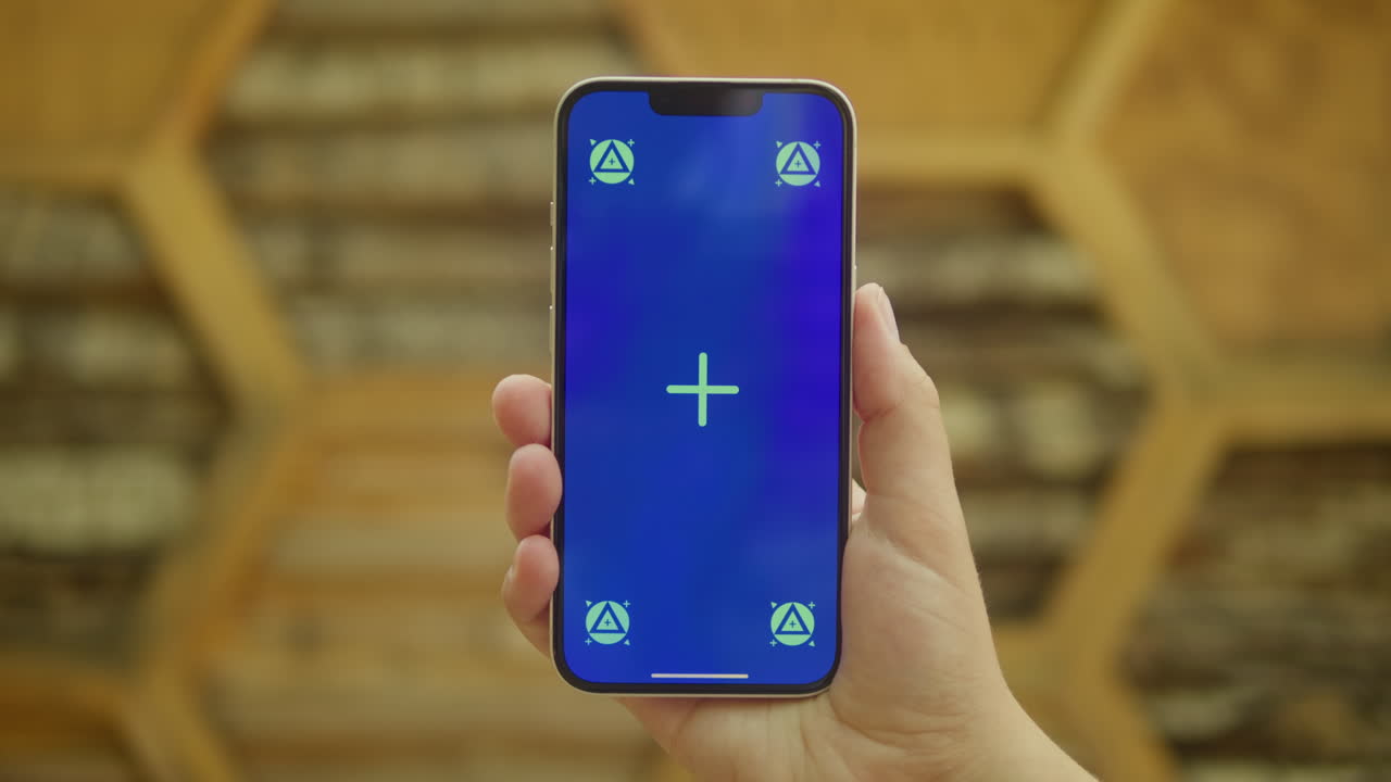 Young woman holding phone chroma key screen in front of wooden background. Girl with green screen on smart phone. Nature