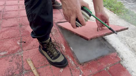 professional latino exterminator pouring powdered chemicals to kill cockroach pest in private mexican residence