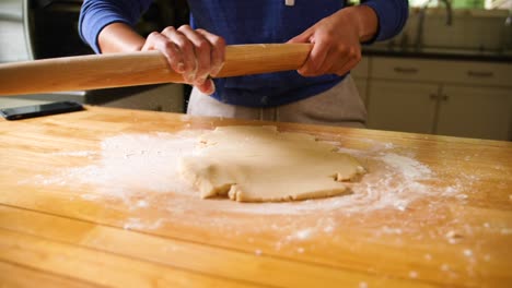 Hands-rolling-dough-with-rolling-pin-on-floured-surface