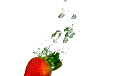 strawberry falling in water on white background