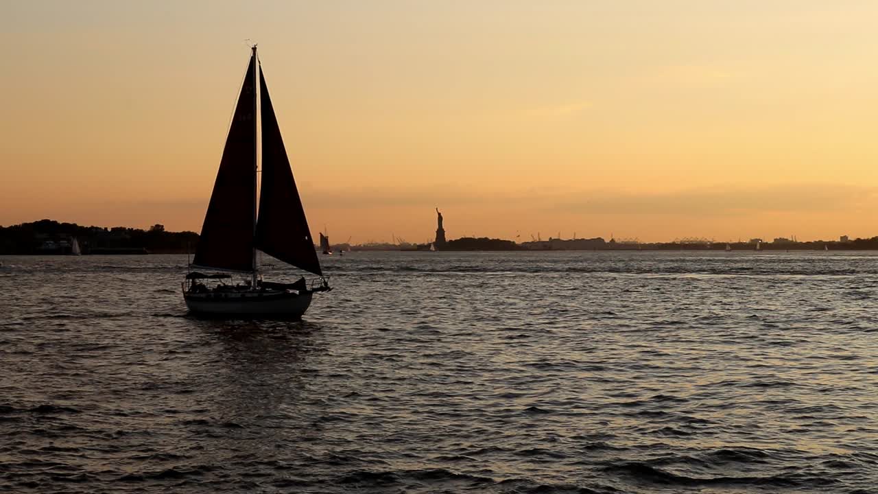 Barca a vela nel fiume Hudson durante il tramonto con la Statua della Libertà sullo sfondo