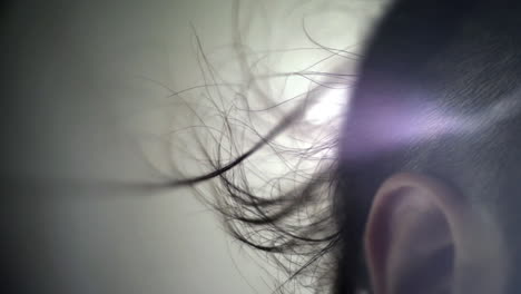 ⁇ 색 바탕에 머리카락의 실루 ⁇ . 머리카락이 귀 위에 바람에 불고 있습니다.