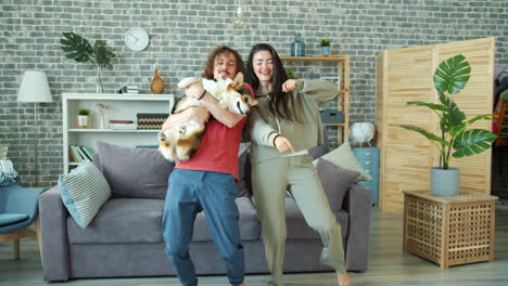 couple dancing with a dog in living room