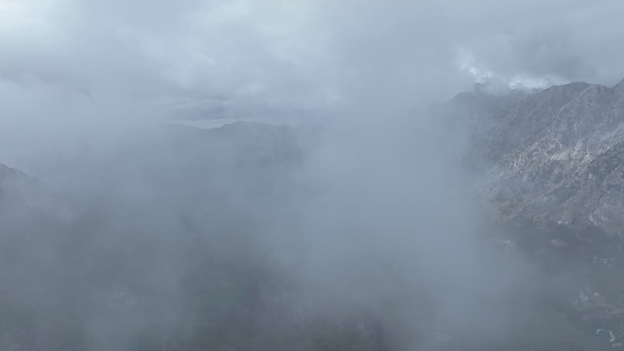 Flying Through The Clouds Over The Mountain Range Near Theth Village In Shkoder County, Albania. - aerial shot
