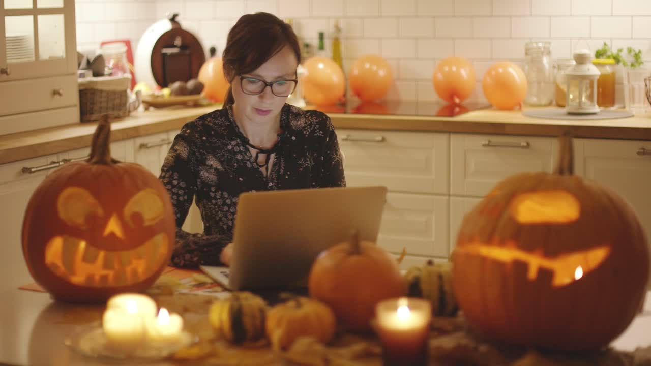 할로윈 장식 근처에서 노트북을 사용하는 여자