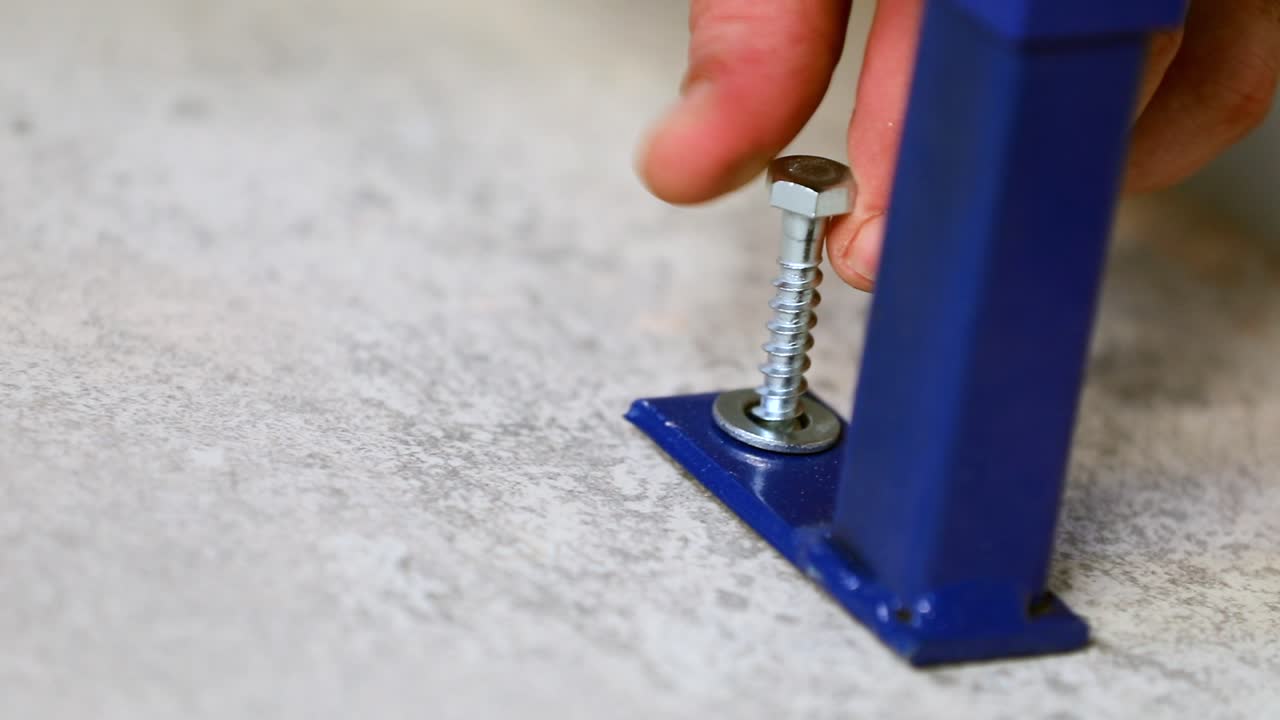 el maestro introduce el perno con su mano.