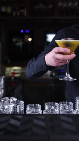 bartender serving a yellow cocktail