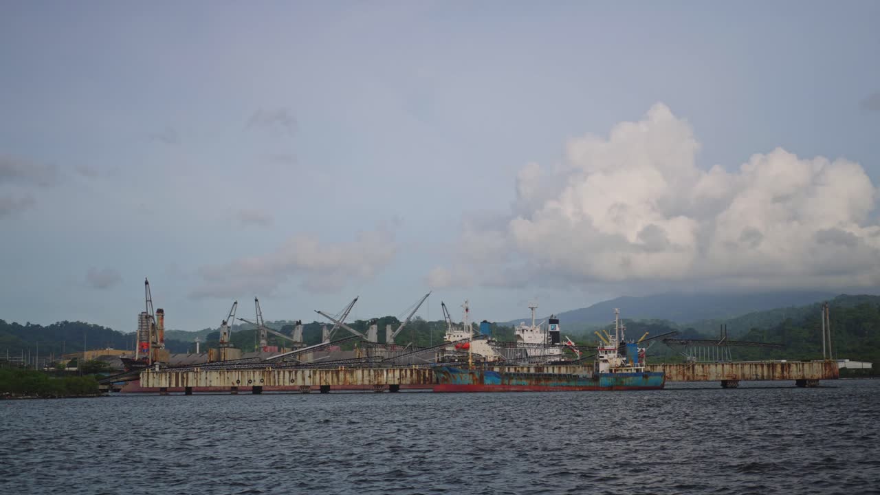 A distant ocean port stands against the horizon, its silhouette blending with the vast sea and open sky.