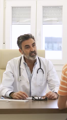 confident male doctor talking to patient in clinic during daytime