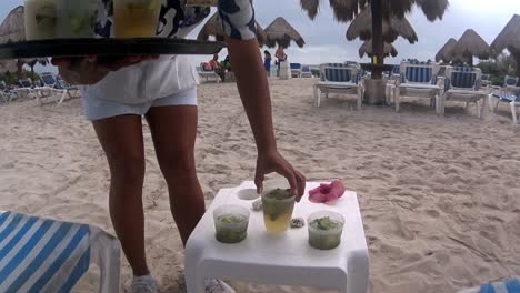 waitress bringing cocktails on the beach