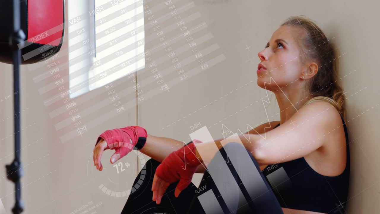 Kvindelig atlet sidder i et hjørne ved en taske, løfter hånden og får fitnesstabeller til at dukke op, som registrerer hvile