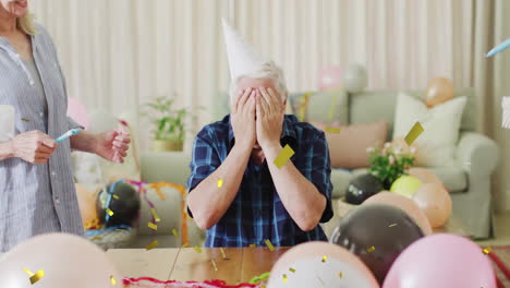 celebration animation over elderly man covering face with hands, surrounded by balloons