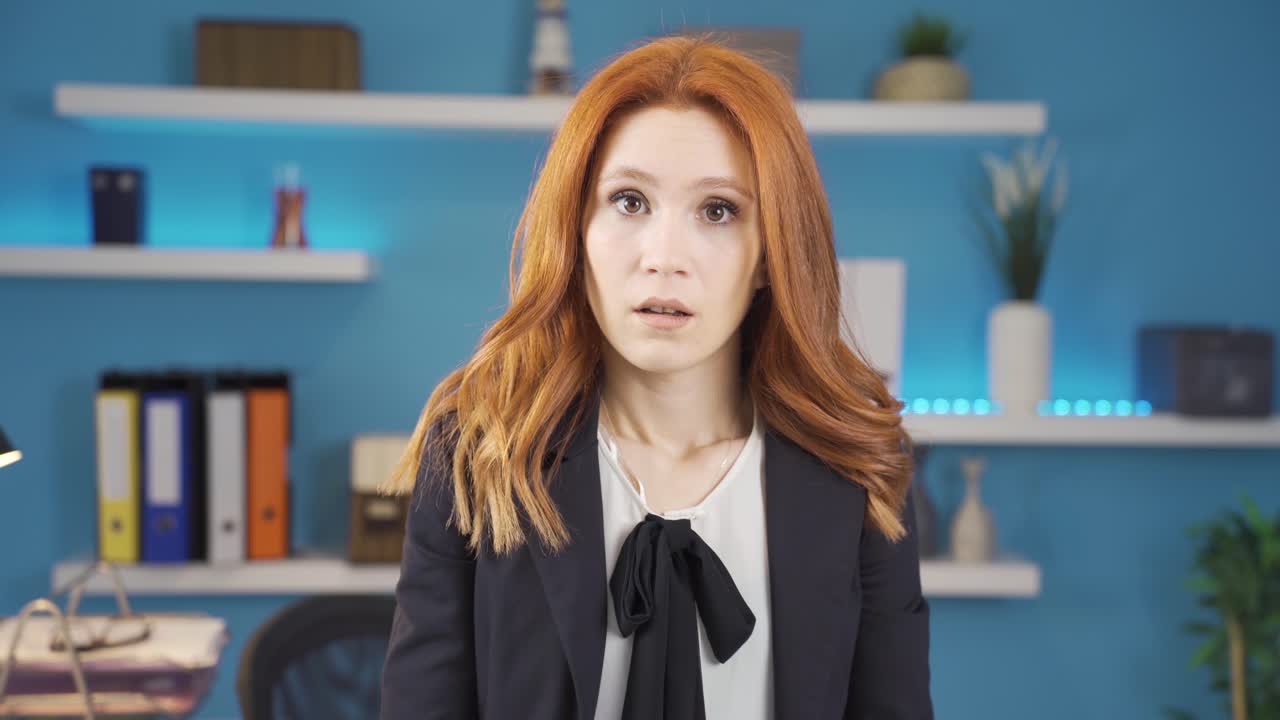 카메라를 바라보는 사업가 여성이 놀라운 얼굴 표정을 짓고 있습니다.