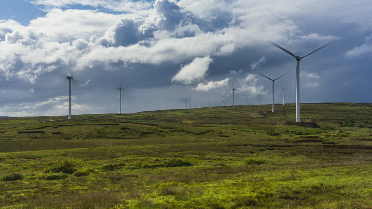 Time lapse of rural landscape with wind turbines on a hillside in the distance on a sunny cloudy day in Arigna mountains in county Leitrim in Ireland