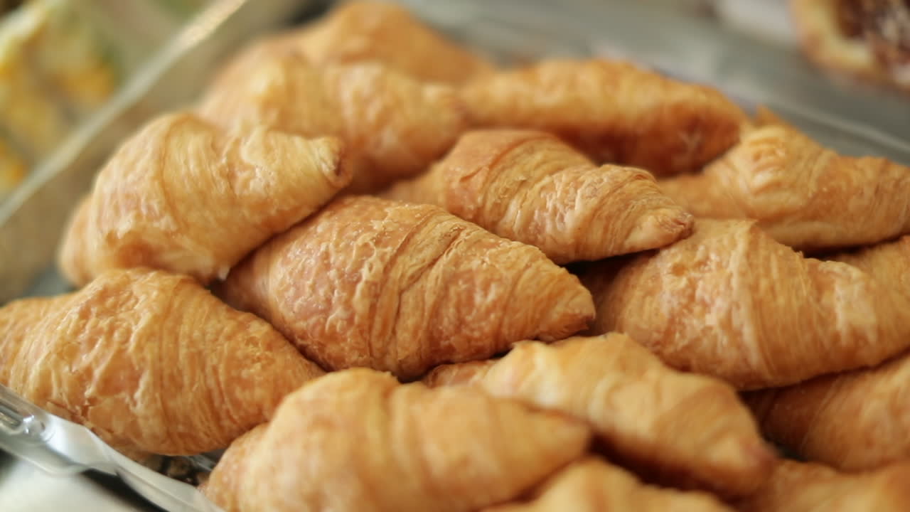 Freshly baked croissants on a tray, close up panning shot