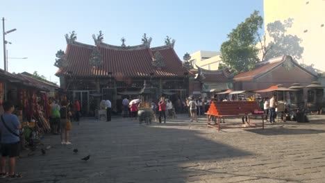 devotees pray at goddess of mercy temple in george town, malaysia - wide shot