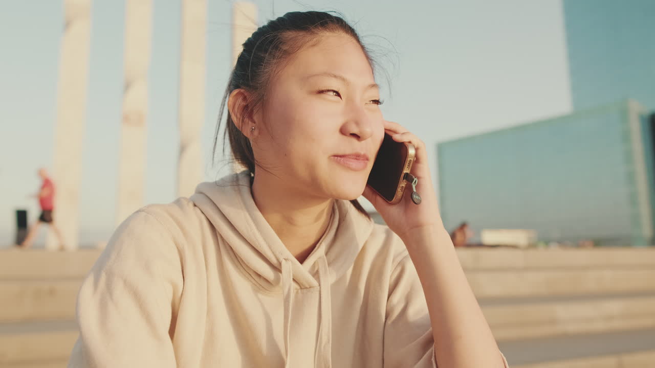 屋外で電話で話している女性