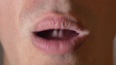 extreme close-up mouth of a youngman coughing