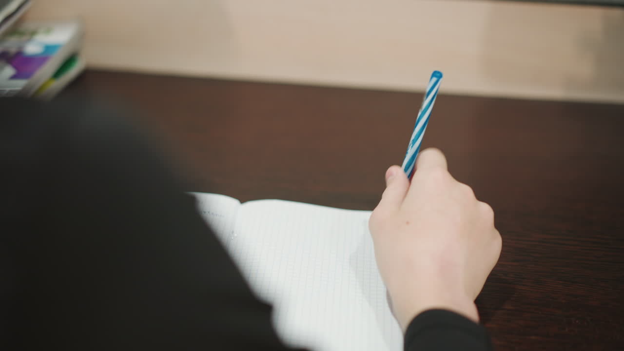 Anziana signora aiuta un bambino con le abilità di scrittura. Calda scena familiare di una nonna che assiste un bambino alla scrivania. Dolce nonna sostiene il nipote durante la pratica di scrittura in un ambiente domestico accogliente.