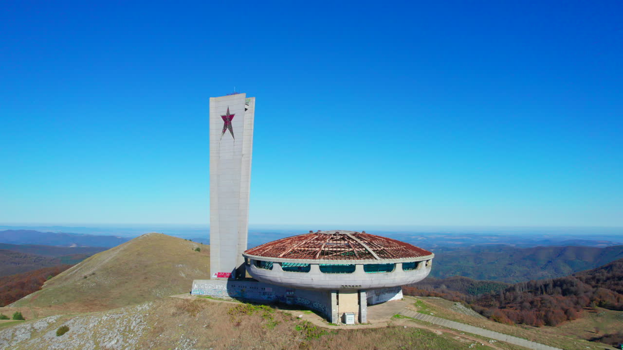 Monumento comunista di Buzludzha in Bulgaria con un simbolo sovietico a stella rossa che si erge su una cima di montagna sotto un cielo azzurro limpido