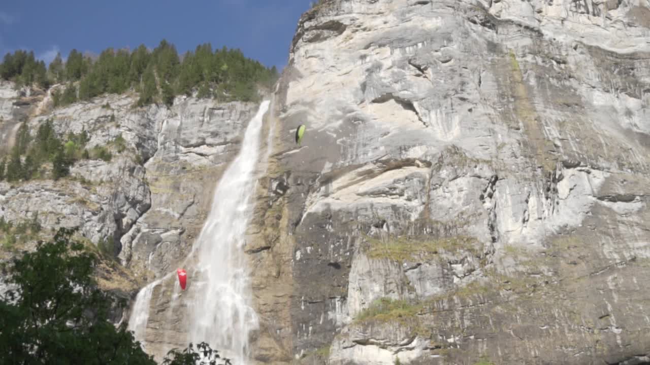 parapenteando cerca de una cascada en los alpes suizos
