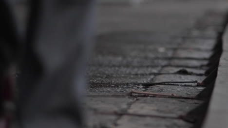 Close-Up-of-shoes-walking-along-cobble-stone