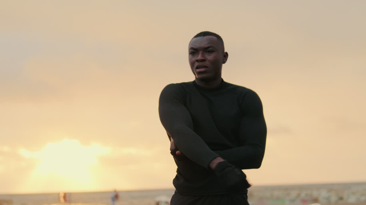 Young Black Man Stretching Arms During Sunset Workout