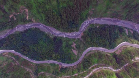 zigzag road top view, kahmir, india, traffice is going on, big forest and green trees, tow zigzag road and a river view from maximum hieght, camera moiving from top with mountaind and roads